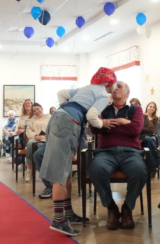 Ellie Hoffman, a Lodge resident modeling in the show, kisses her husband Tom during her walk on the runway.